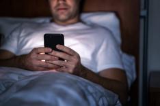 Man with smartphone before sleeping